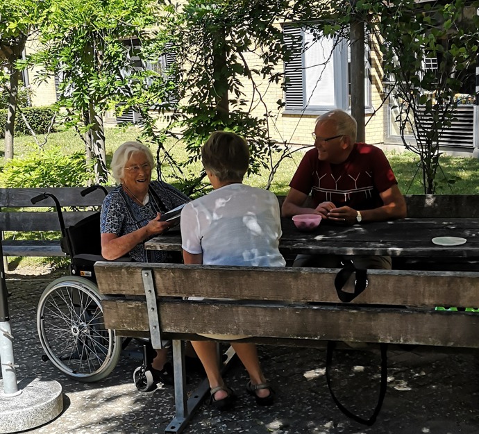 Ældre har udendørs besøg af pårørende på Plejecenter Baunehøj